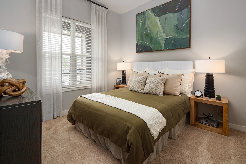 a bedroom with a bed and a large green painting