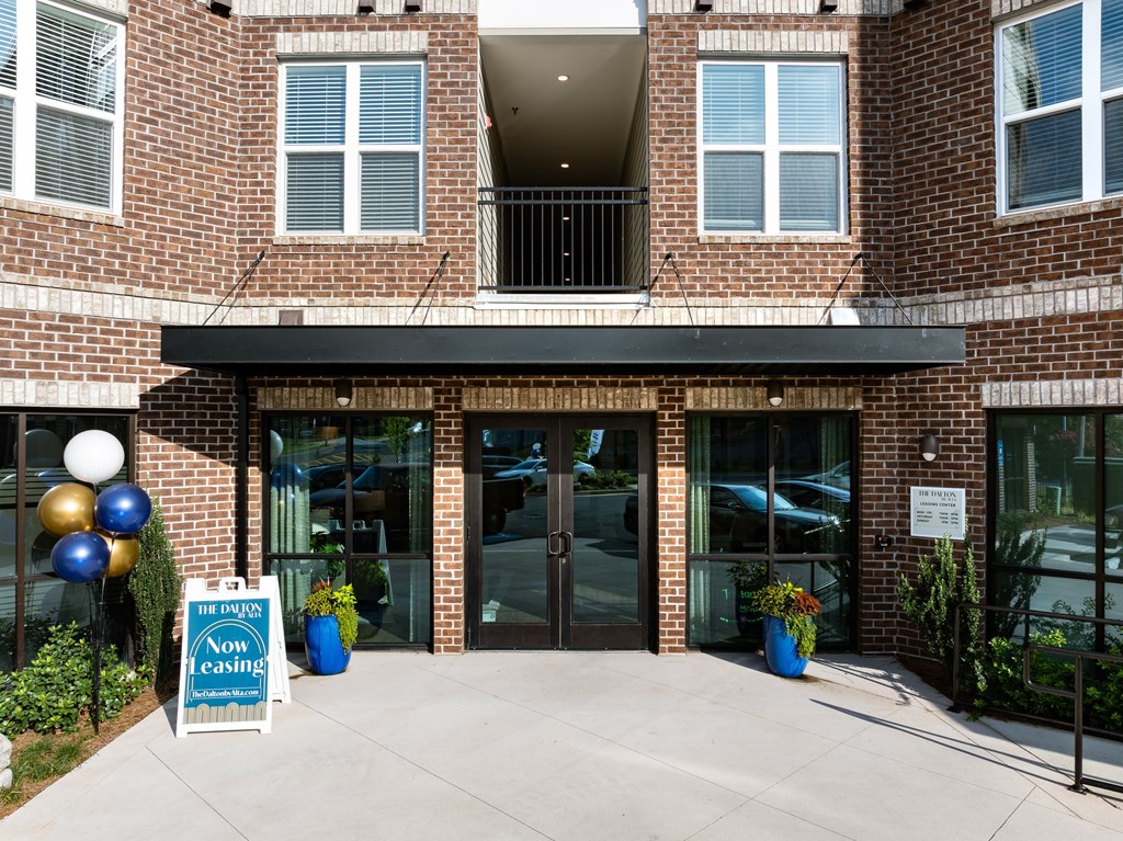 A building with a sign that says "Now Open" in front of it.