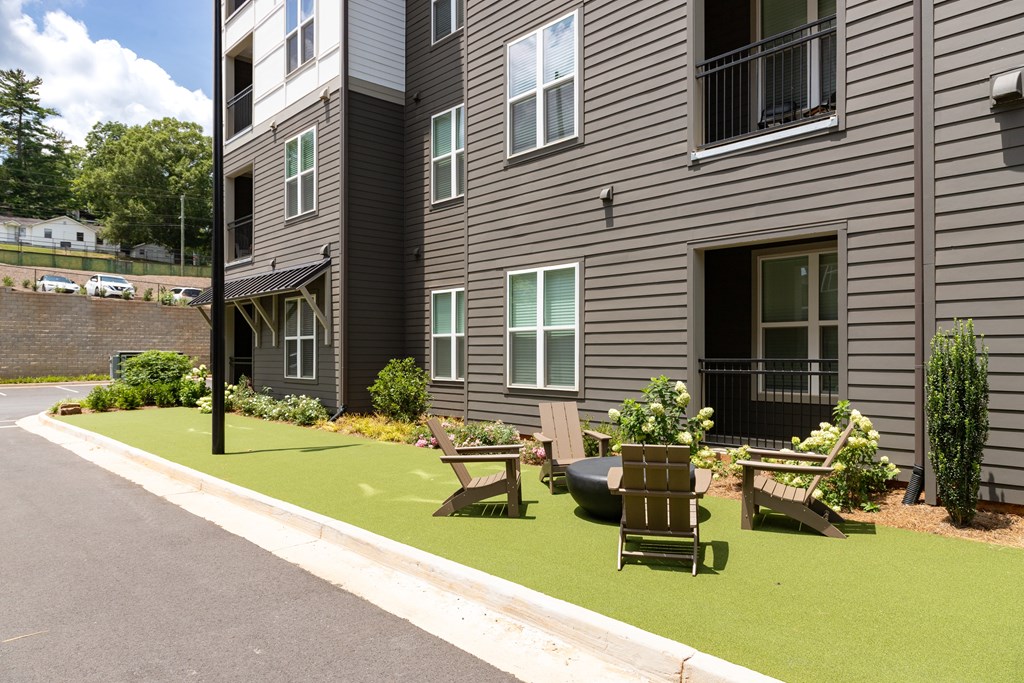 A grey building with a green lawn in front.