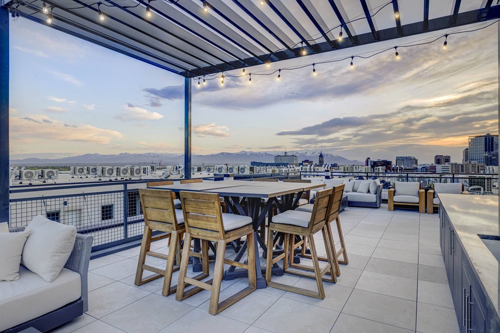 a terrace with a table and chairs and a view of the city