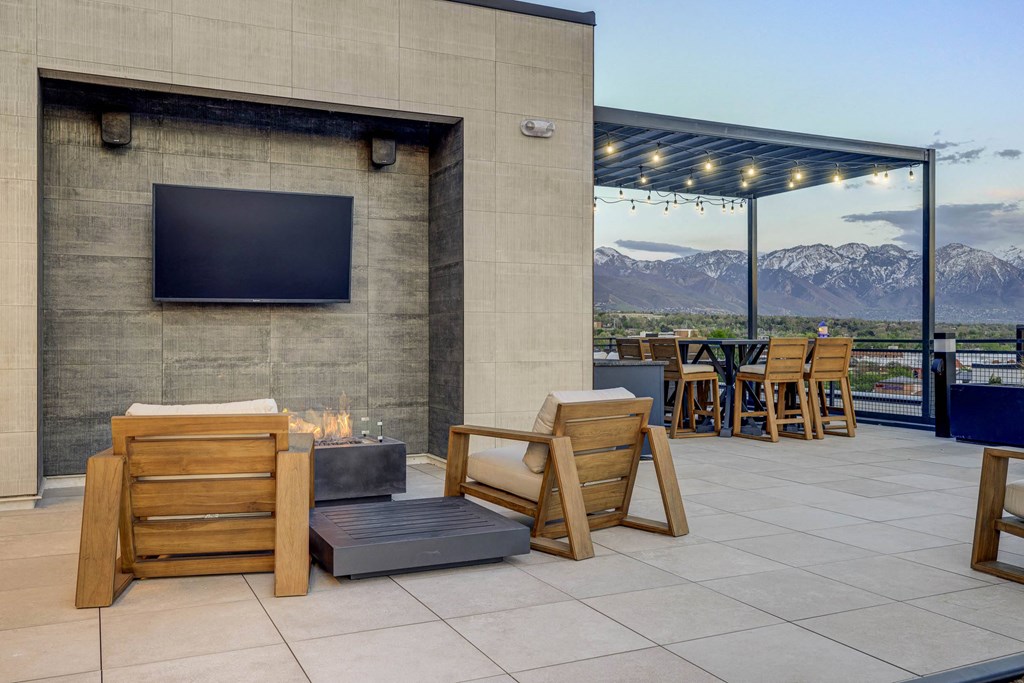 the patio has a fire pit and a tv on the wall
