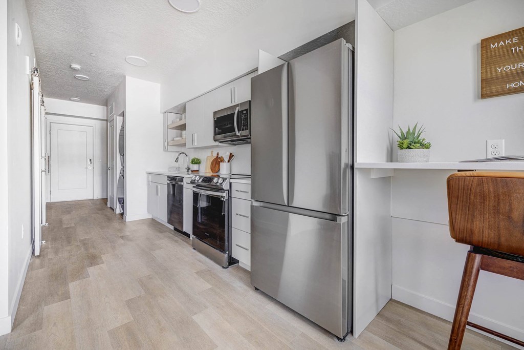 a kitchen with stainless steel appliances and a wooden floor