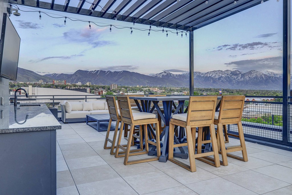 a patio with a table and chairs and a view of the mountains