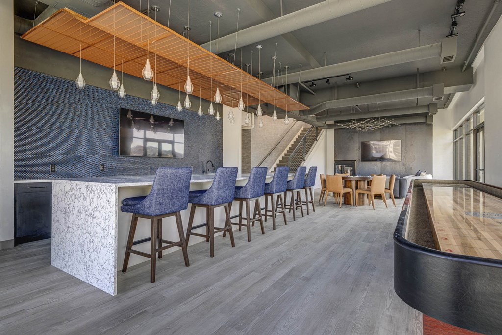 a lobby with bar stools and chairs and a bar with a counter
