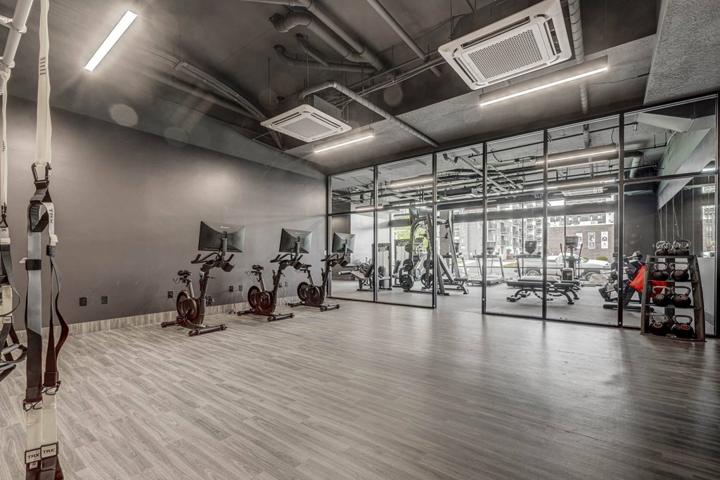 a gym with weights and exercise equipment in a glass walled room