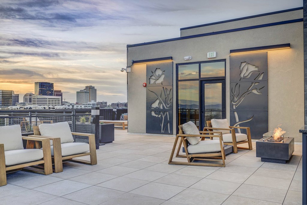 a roof deck with chairs and a view of the city