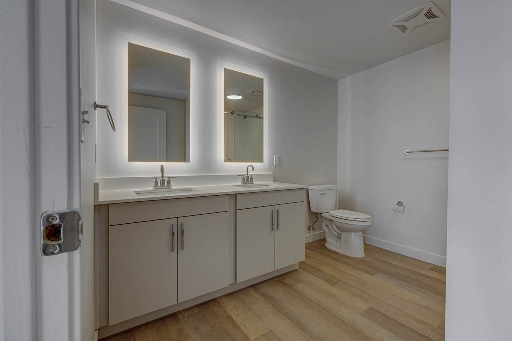 double vanity bathroom with back-lit mirrors