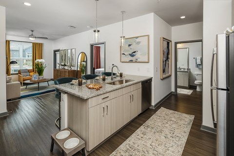 A modern kitchen with a wooden island and a refrigerator on the right.