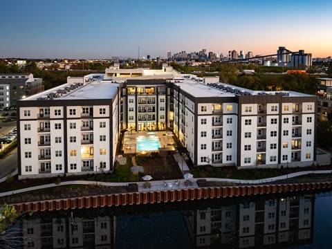 A modern apartment building with a pool in the middle of it.