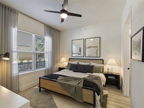 a bedroom with a bed and a ceiling fan