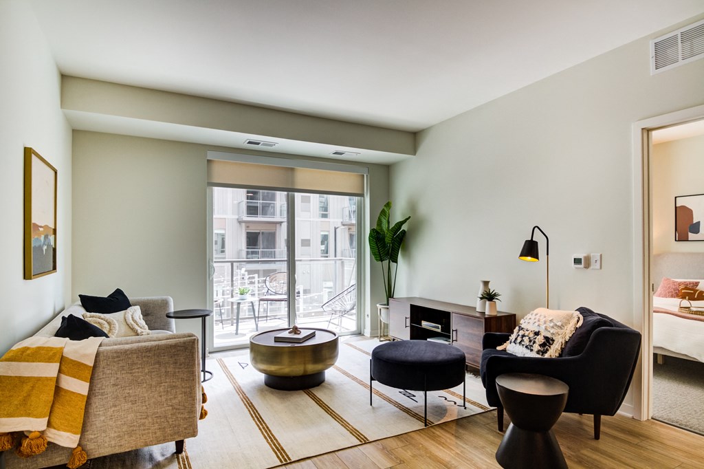 a living room with a couch and chairs and a balcony