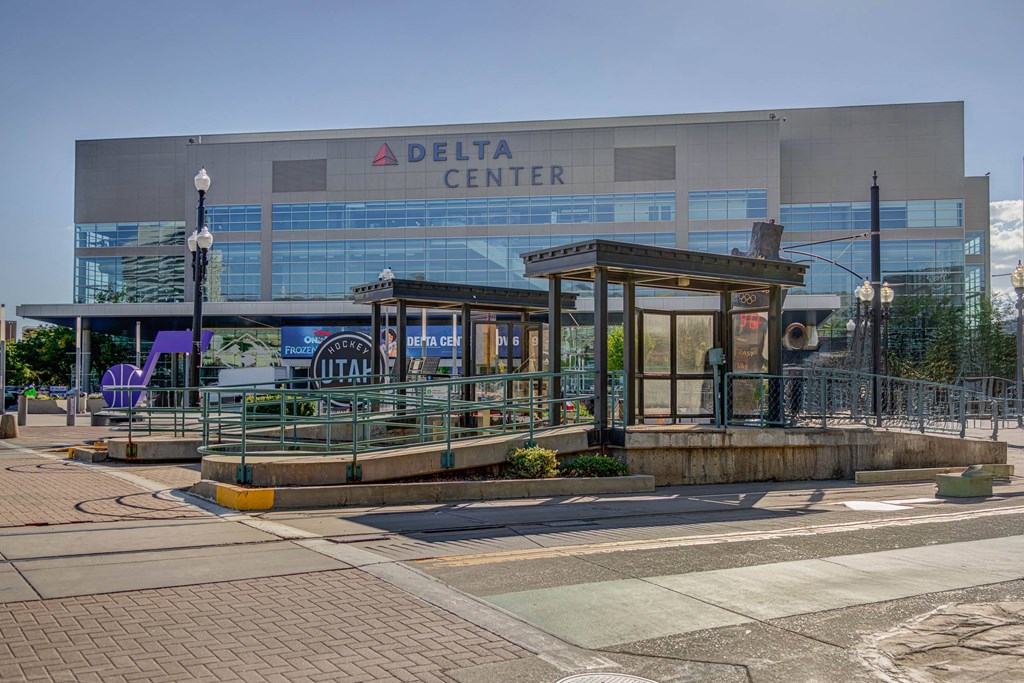 A Delta Center building with a glass facade and a small wooden structure in front.
