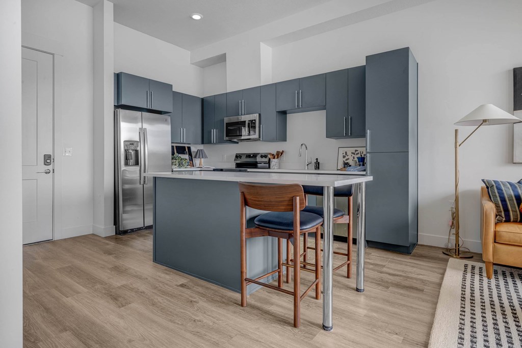 A kitchen with a table and chairs.