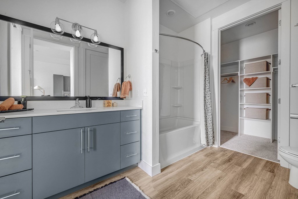 A bathroom with a large mirror and a walk-in shower.