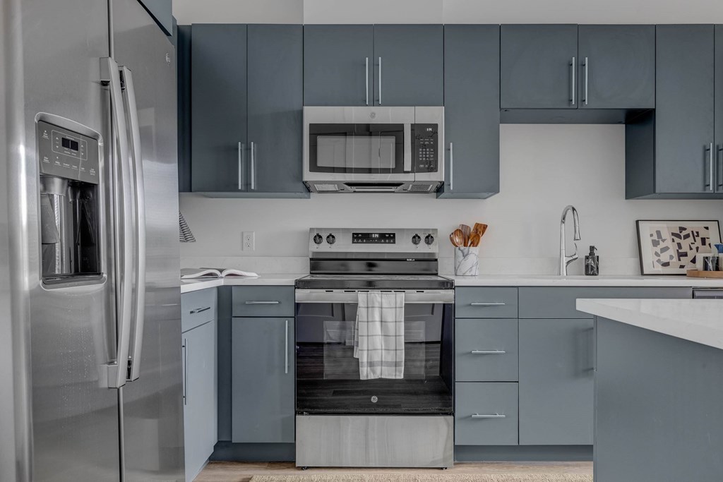 A modern kitchen with a stainless steel refrigerator and a stove top oven.