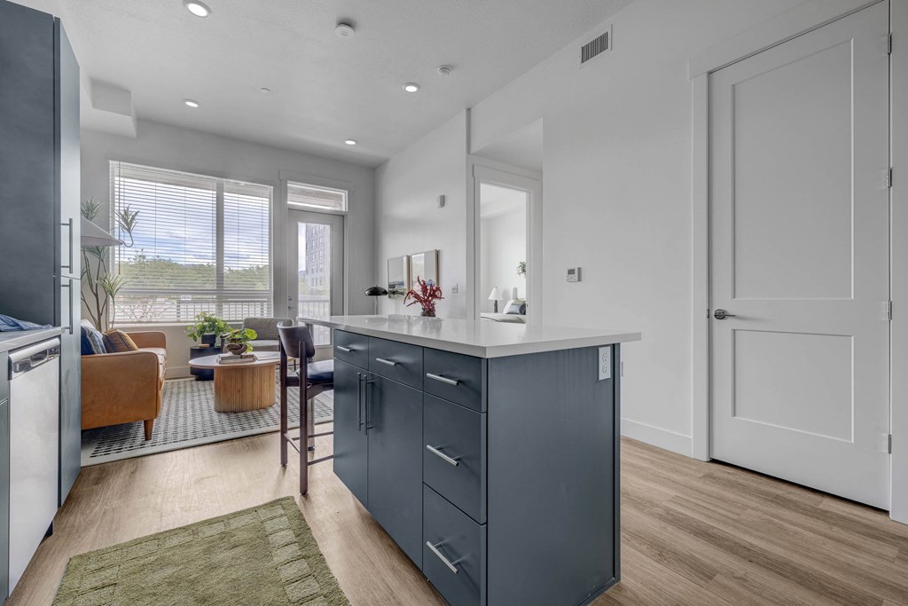 A modern kitchen with a large island and a view of the outdoors.