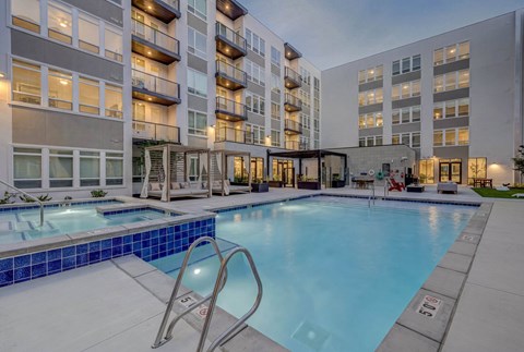 A large swimming pool in front of apartment buildings.