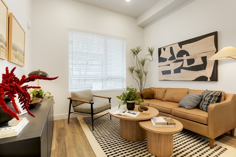 A living room with a couch, chair, and a table with a vase on it.