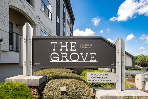 A sign that says The Grove in front of a building.