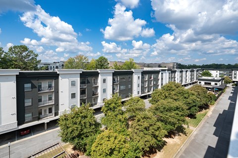 A row of modern apartment buildings are lined up on a street.