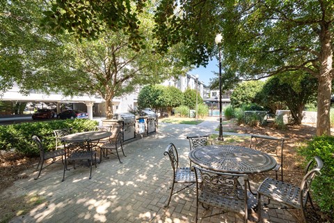 A patio with a table and chairs surrounded by trees.