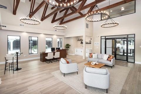 A spacious living room with a high ceiling and wooden beams.