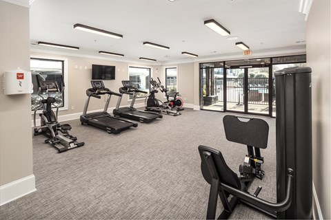 A gym with treadmills, elliptical machines, and other exercise equipment.