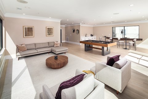 A living room with a pool table and a bar area.