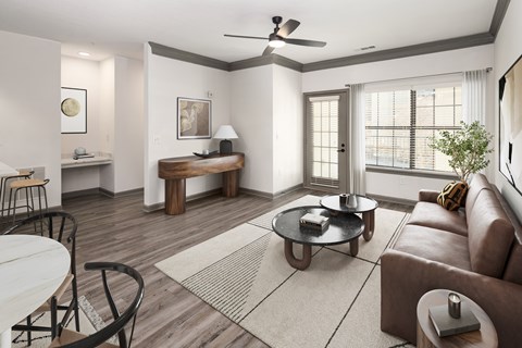 A living room with a brown leather couch and a white table.