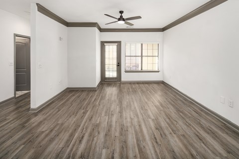 A room with wooden floors and a ceiling fan.