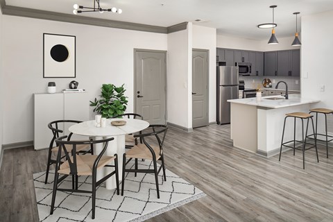 A modern kitchen with a dining table set for four.