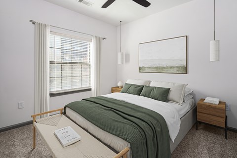 A bedroom with a bed, a window with blinds, a ceiling fan, and a painting on the wall.