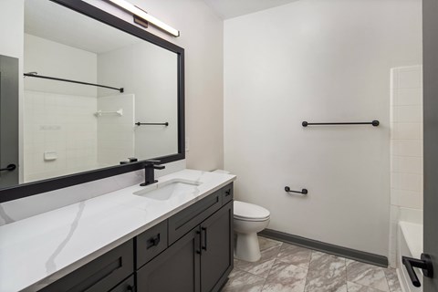 A bathroom with a white counter top and a toilet.