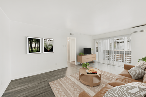 A living room with a brown couch, a coffee table, and two framed pictures on the wall.
