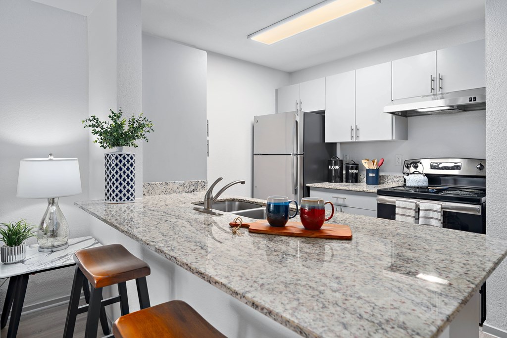 A kitchen with a marble countertop and a stool.