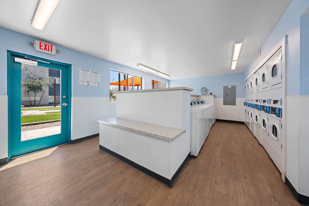 A laundromat with a blue door and a washer and dryer.