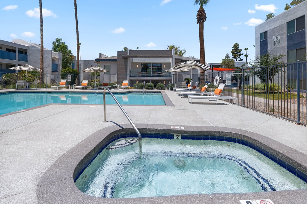 A hot tub sits in the middle of a pool surrounded by chairs.
