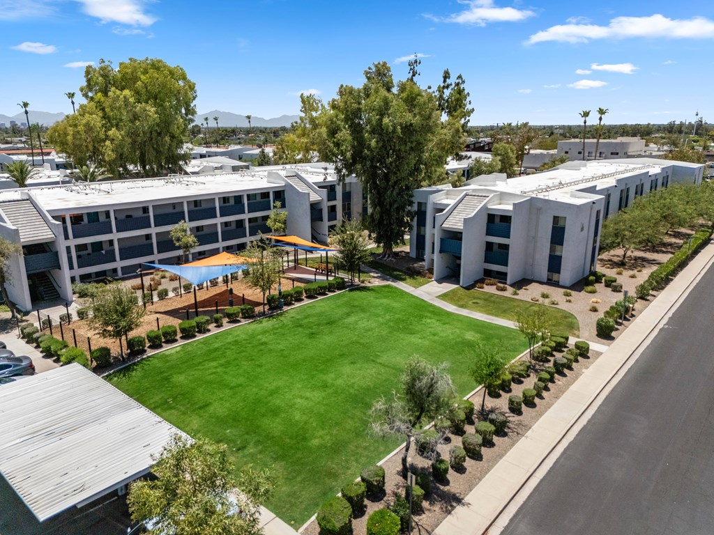 A large building complex with a green lawn in front.