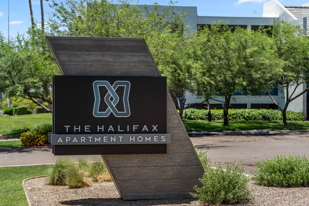 A sign for The Halifax Apartment Homes is displayed in front of a building.