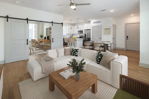 a living room with a white couch and a coffee table in front of a kitchen