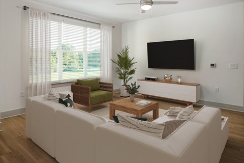 a living room with a white couch and a television