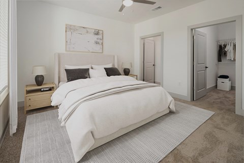 a white bedroom with a large bed and a closet