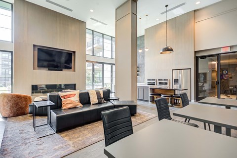 a living room with a couch table and chairs and a flat screen tv on the wall