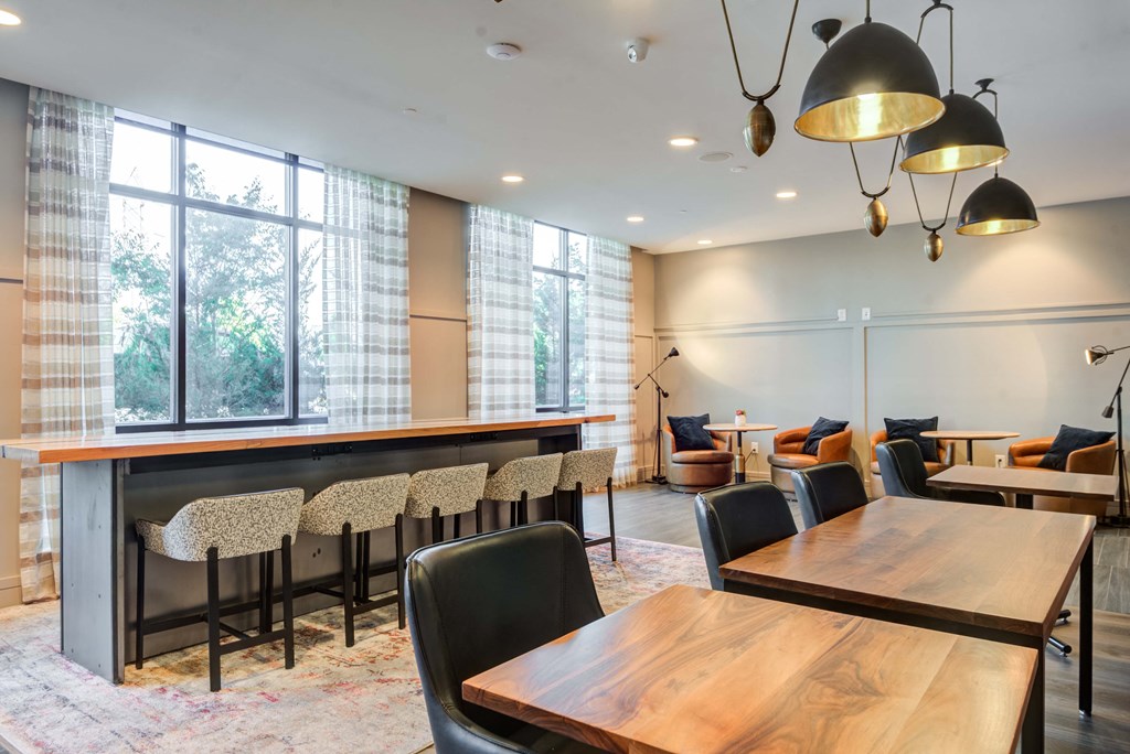 a room with a long wooden table and chairs and a large window