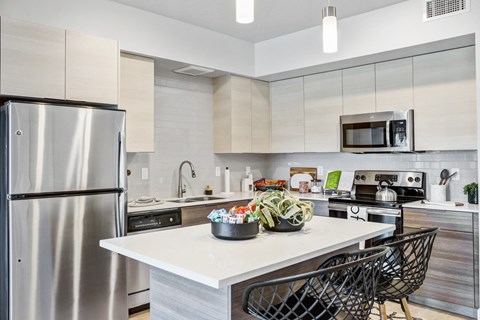A modern kitchen with a stainless steel refrigerator and a white countertop.