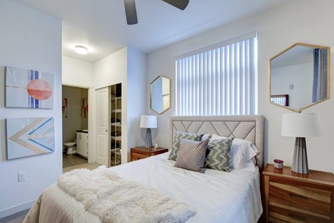 A bedroom with a large bed and a painting on the wall.
