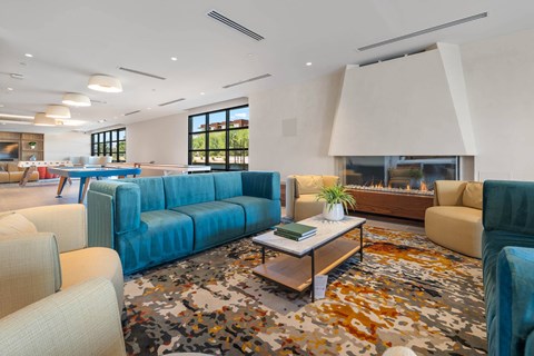 A modern living room with a blue sofa and a patterned rug.