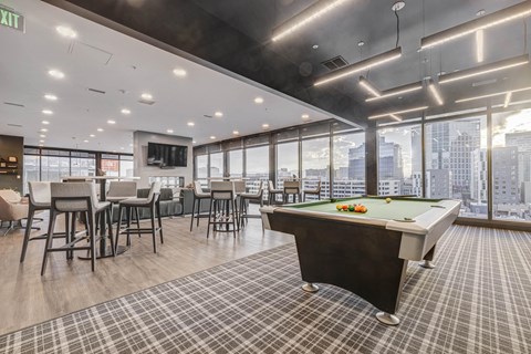 a games room with a pool table and a view of the city