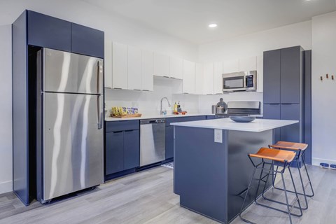 A modern kitchen with a large island and stainless steel appliances.