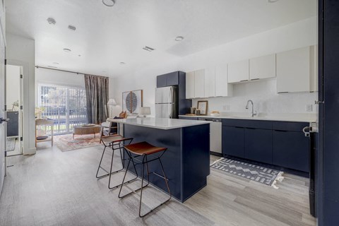A modern kitchen with dark blue cabinets and a wooden island.